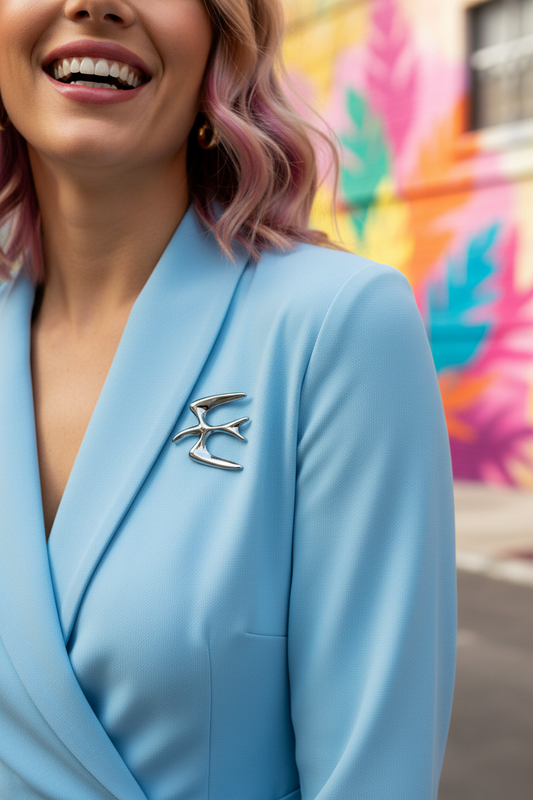 Broche hirondelle argentée sur combi bleu ciel