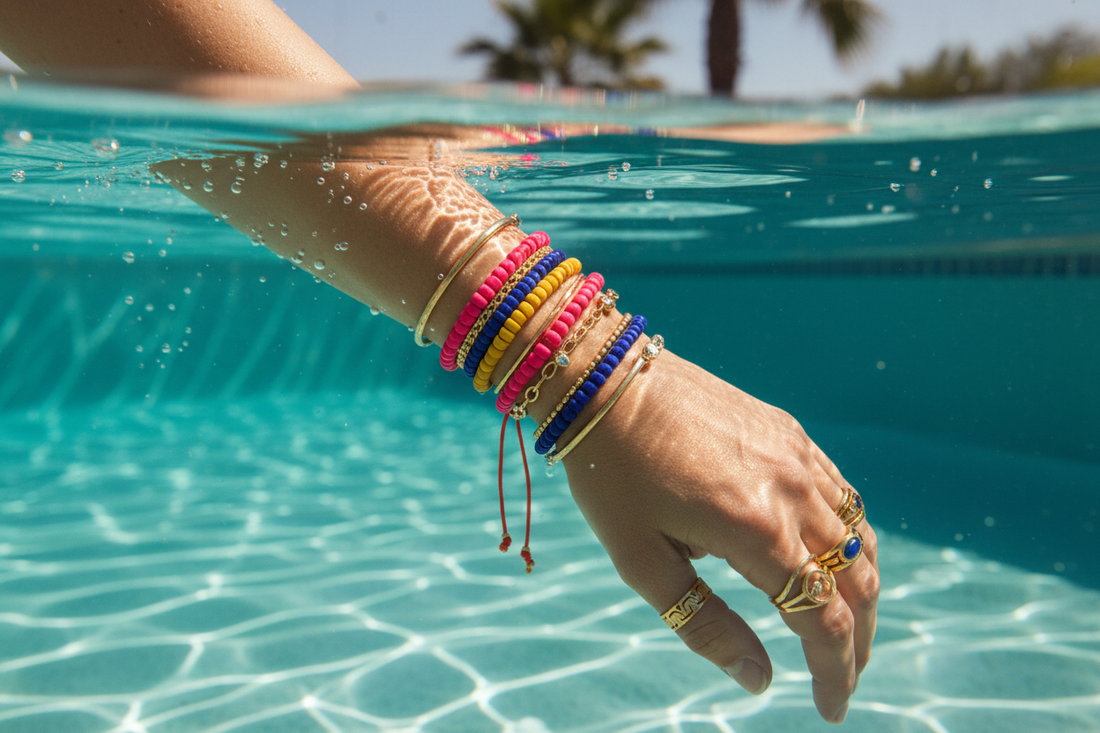 Bras de femme dans une piscine avec bagues et bracelets dorés waterproof - Chéri Chérie